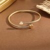 Elegante pulsera de diseño trenzado en tono dorado, adornada con dos delicados corazones en los extremos. Su estructura ajustable y minimalista la convierte en un accesorio perfecto para destacar en cualquier ocasión.