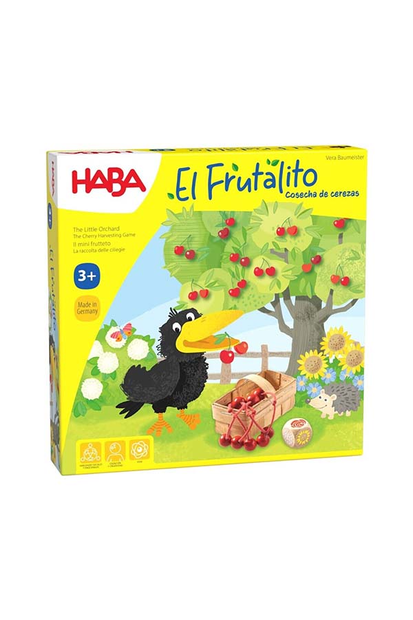 En esta imagen se presenta la caja del juego El Frutalito: Cosecha de Cerezas de HABA. El diseño muestra un colorido cerezo lleno de deliciosas cerezas rojas, mientras un cuervo observa con curiosidad. Esta ilustración invita a los más pequeños a participar en una aventura cooperativa de recolección de frutas antes de que el travieso pájaro las robe.