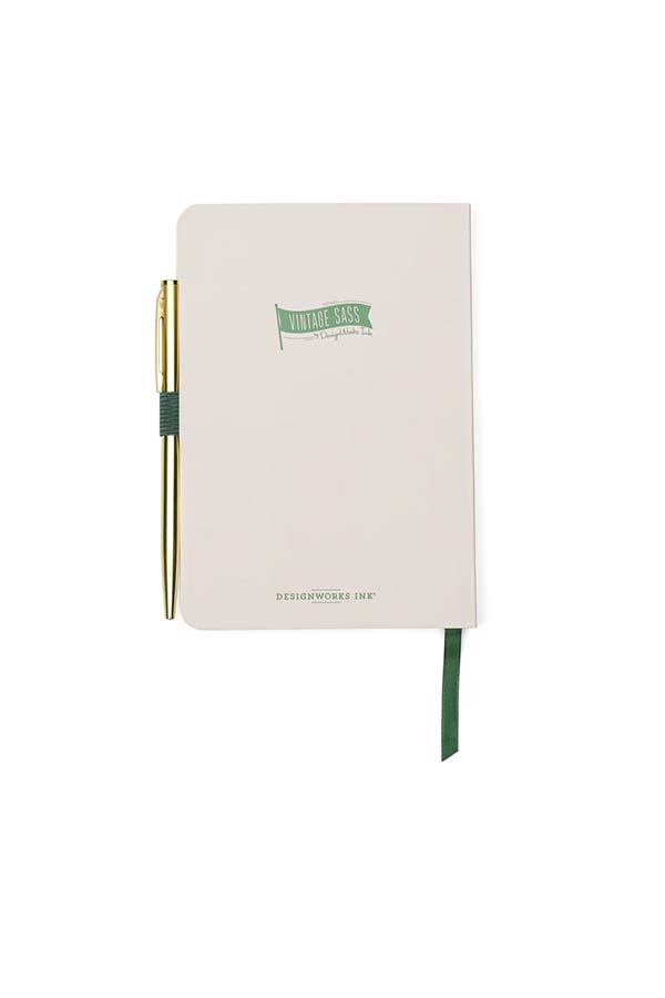 Vista trasera del cuaderno compacto "For Fox Sake", en color beige con un pequeño logotipo de "Vintage Sass" en verde. El bolígrafo metálico dorado está sujeto a la banda elástica lateral, y la cinta marcapáginas verde sobresale por la parte inferior.