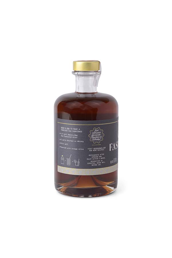 Botella de mezcla para preparar un clásico cóctel Old Fashioned. Elaborada con ingredientes cuidadosamente seleccionados para obtener un sabor equilibrado y sofisticado. La etiqueta incluye instrucciones para su preparación, recomendando combinar con bourbon o whisky, añadir hielo y remover bien. La botella tiene un diseño elegante con detalles dorados y un tapón dorado para mayor conservación.