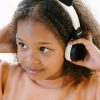 Niña disfrutando de su música con los auriculares panda de Kidywolf, ajustables y perfectos para niños.